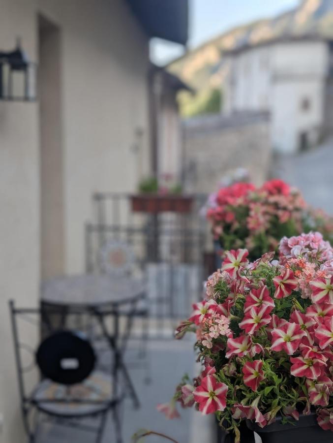 Gerani sul balcone e i tetti del borgo